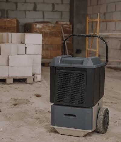 Verrijdbare bouwdroger op een bouwplaats bij pallets metselstenen