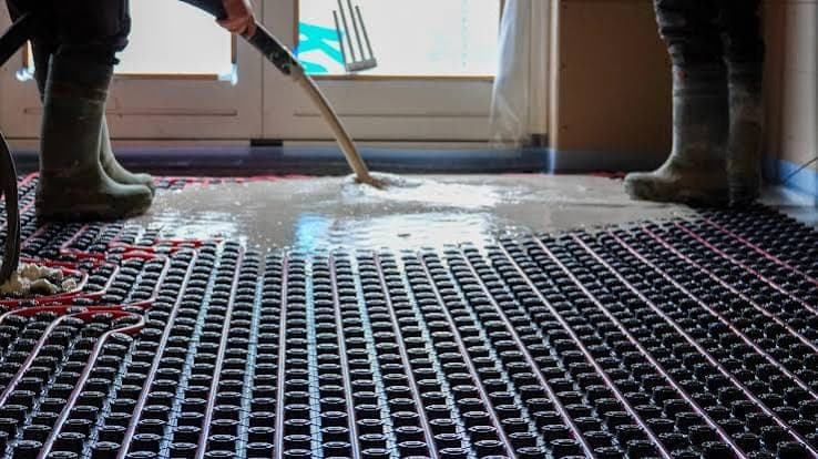 Verse dekvloer wordt gegoten over vloerverwarming