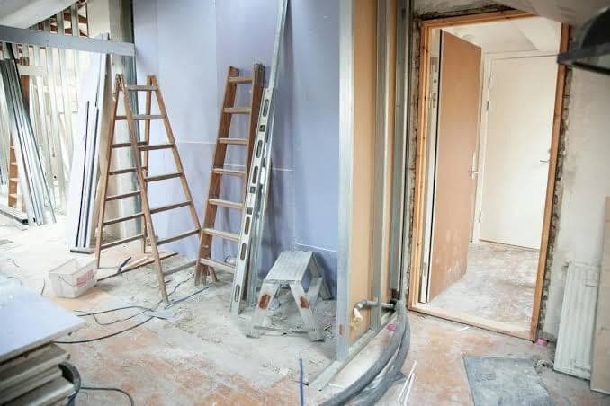 Woning in verbouwing met ladders en gestripte wanden